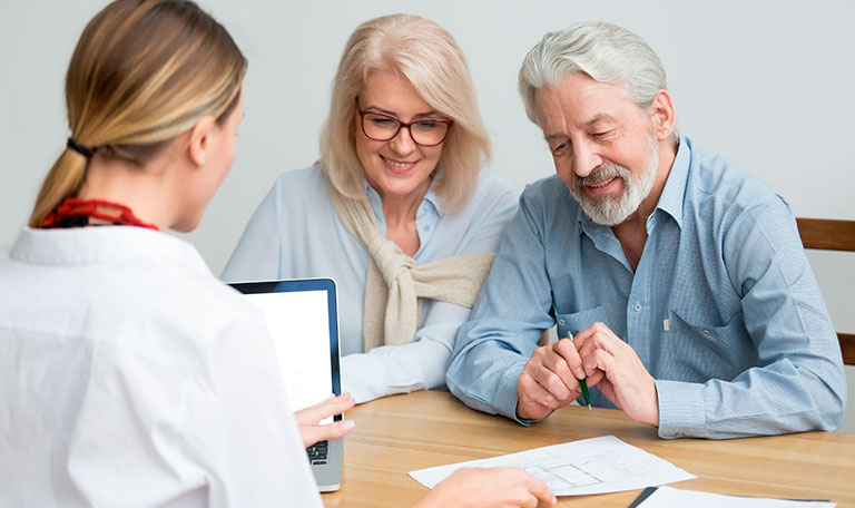 Stock image of an older couple in a consultation with a dentist.